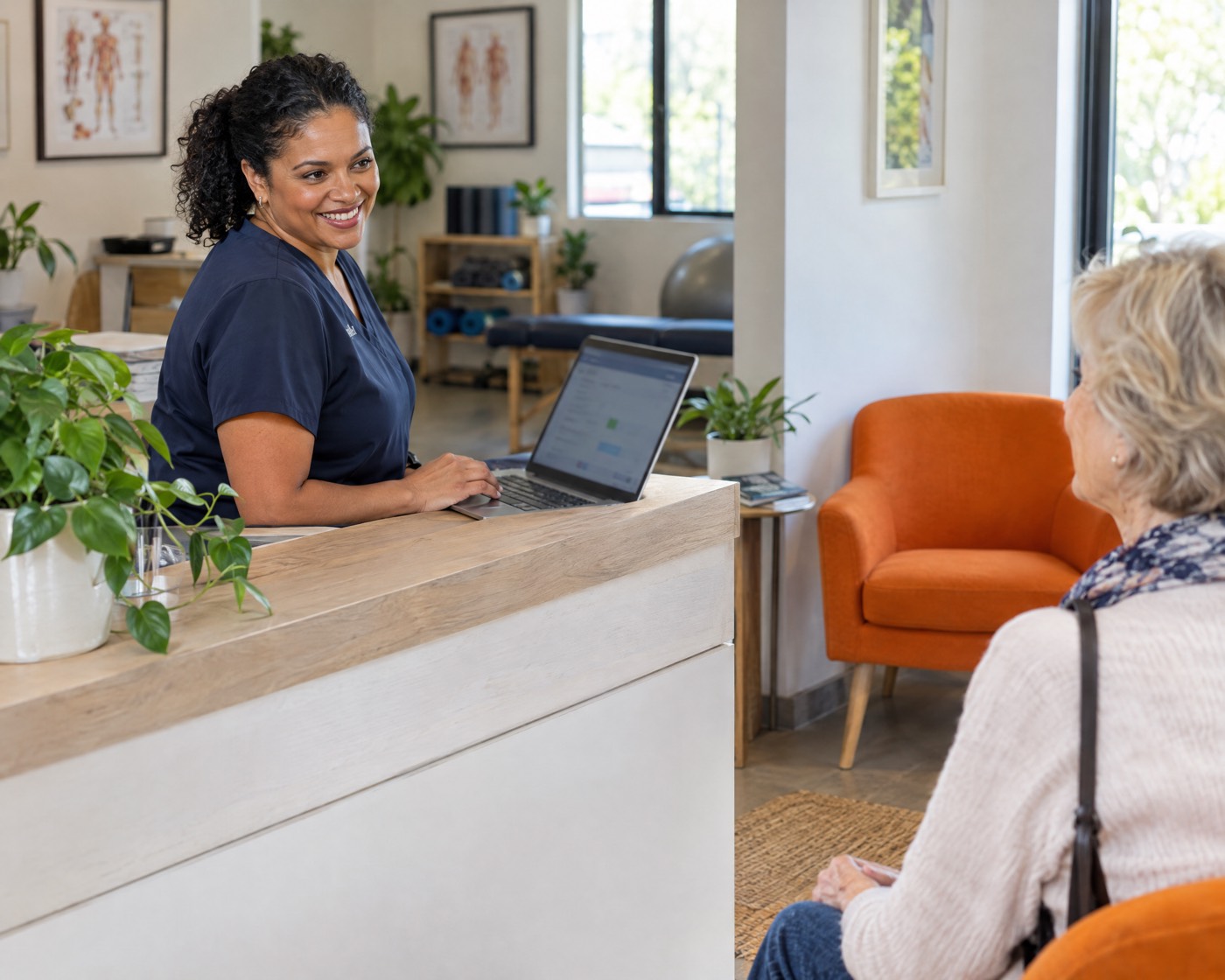 Physiotherapy practice owner confirming an online booking at reception